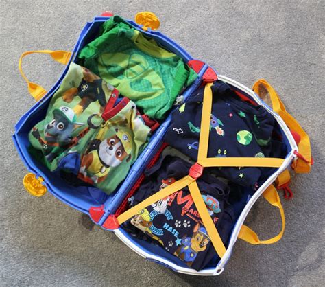 inside view of a trunki suitcase packed with snacks, toys, and a plush animal