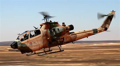 Iranian Bell AH-1J Cobra attack helicopter flying low over terrain