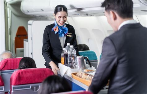 japan airlines flight attendants serving passengers in business class
