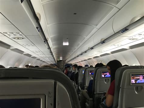 JetBlue Airbus A320 interior with seatback screens and passengers
