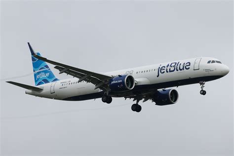 jetblue airbus a321lr parked at edinburgh airport with festival banners in background