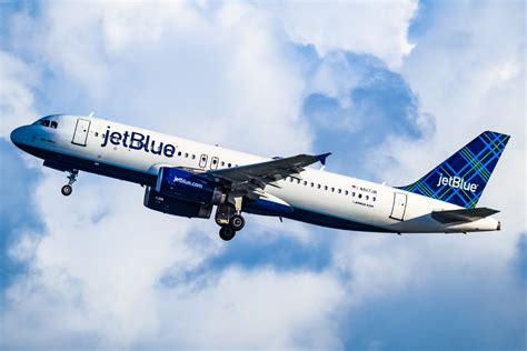 JetBlue aircraft departing New York JFK runway during sunset