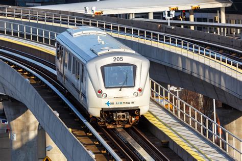 JFK AirTrain car moving along the track with terminal signage visible