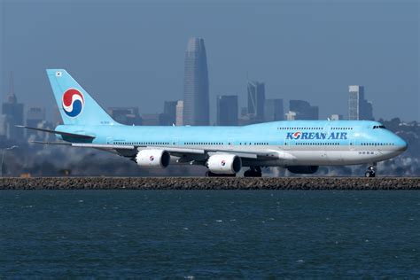 Korean Air Boeing 747-8 parked at gate in Frankfurt Airport under light snowfall