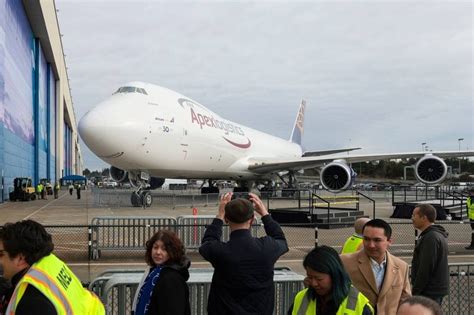 last Boeing 747-8 delivery ceremony with factory workers and aircraft in background