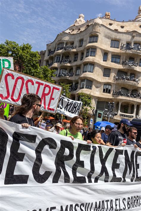 lisbon residents marching against tourism gentrification holding banners in city center