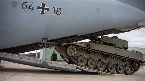 Loadmasters guiding Puma IFV into final flight position in A400M cargo hold