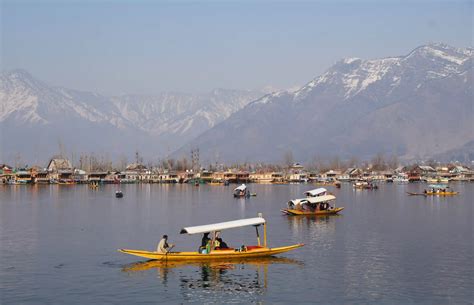 local Kashmiri houseboat owner preparing traditional wazwan meal on Dal Lake
