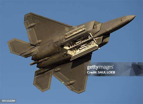 Lockheed Martin F-22 Raptor stealth fighter jet at high altitude with weapons bay open