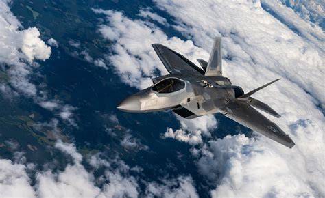 Lockheed Martin F-22 Raptor supercruising above mountain clouds
