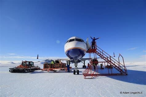logistics aircraft unloading supplies on Antarctic blue ice surface near research station