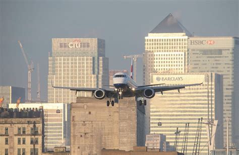 London City Airport steep approach aircraft over city skyline landing