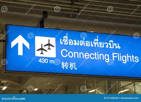 long airport corridor between terminals with signage for connecting flights