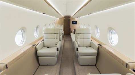 luxury flight attendant adjusting table setting in Gulfstream cabin with fine china and caviar