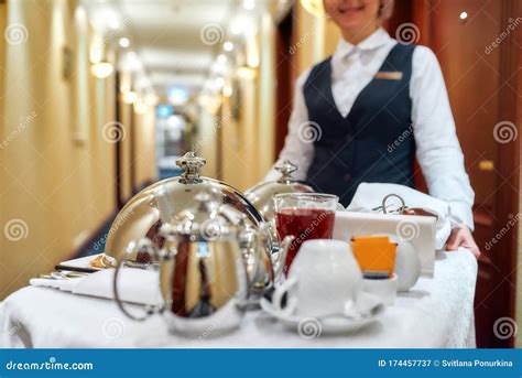 luxury hotel corridor with room service staff delivering tray