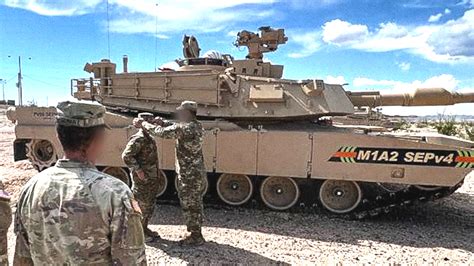 M1 Abrams tank crew member loading 120mm main gun ammunition