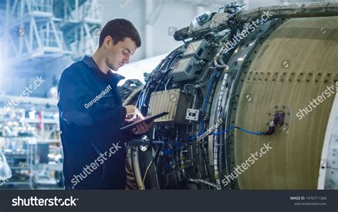maintenance crew inspecting grounded embraer jet in regional airport