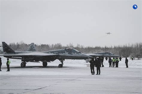 maintenance crew servicing a Su-57 fighter on a modern airbase