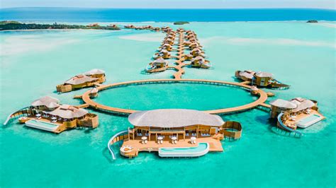 Maldives overwater villas turquoise lagoon aerial luxury resort