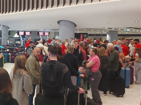 Manchester Airport terminal with stranded passengers during weather delays