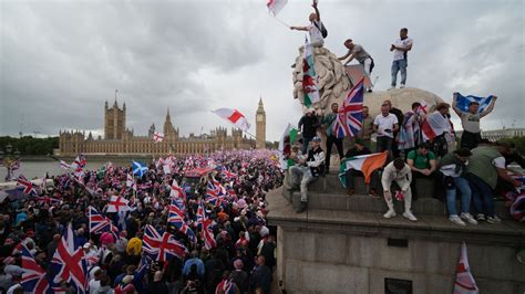 masked far-right demonstrators holding nationalist flags along Budapest’s Margaret Bridge