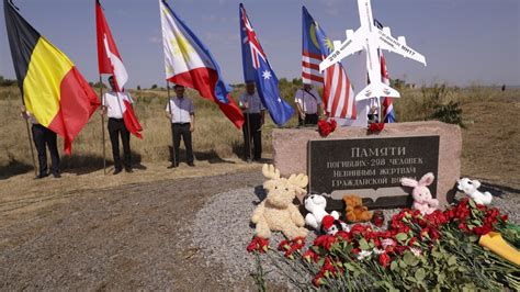 Memorial for MH17 victims with aircraft model and flags at crash site