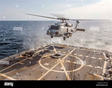 MH-60R Sea Hawk preparing to land on destroyer deck during maritime exercise