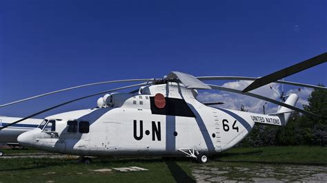 mil mi-26 heavy lift helicopter in flight over mountainous terrain