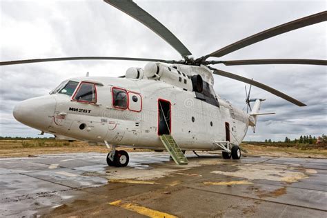 Mil Mi-26 helicopter parked at a Siberian airfield with refueling trucks nearby