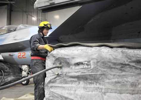 military aircraft crash recovery team removing aluminum debris in protective hazmat equipment