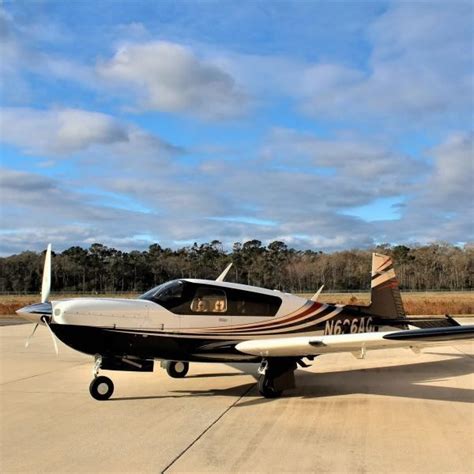 mooney ovation ultra parked on executive ramp under sunset