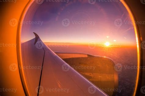 mountain view from airplane window with glowing sunrise sky
