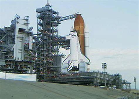 nasa headquarters at night with american flag and launch pad in background