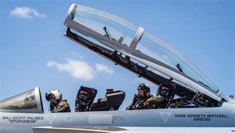 navy pilot saluting inside fa-18 super hornet cockpit before takeoff on carrier deck