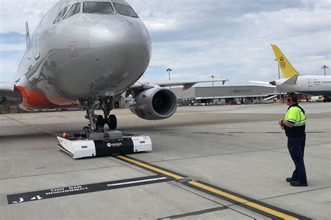 nighttime airport pushback with illuminated tug and aircraft ready for departure
