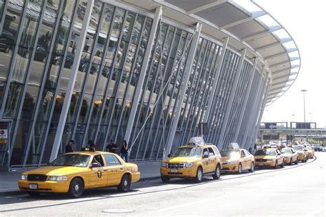 nyc taxi picking up passengers at jfk curbside