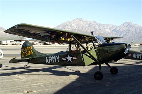 O-1 Bird Dog military aircraft taxiing in jungle airstrip