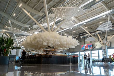 Odesa Airport main terminal entrance with Ukrainian flag in foreground under cloudy sky