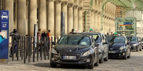 Official Paris taxi stand outside CDG Terminal 2 with travelers waiting