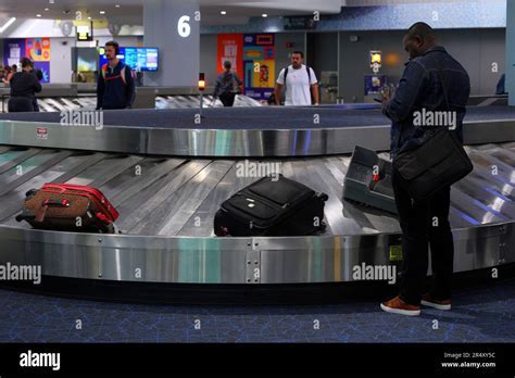 overflowing airport luggage carousel with irate passengers waiting
