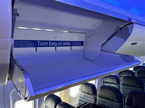 Overhead bin packed with personal carry-on luggage on Southwest flight