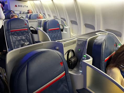 Passenger relaxing in Delta One lie-flat seat during domestic flight