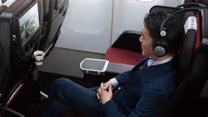 Passenger relaxing in Japan Airlines premium economy during long-haul flight