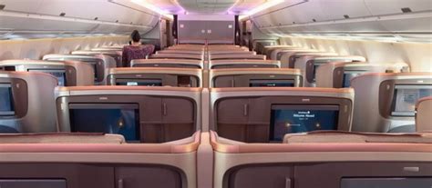 passenger relaxing in lie-flat business class seat with window view during long haul flight