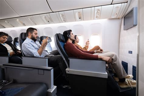 passenger relaxing in wide premium economy seat with extended leg rest