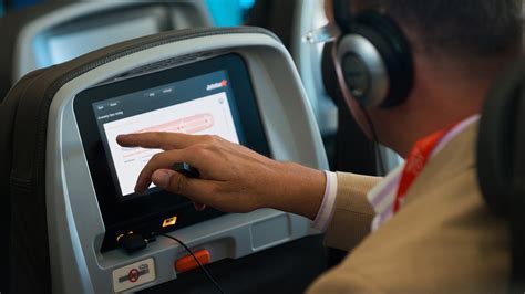 Passenger using United in-flight entertainment system with headphones