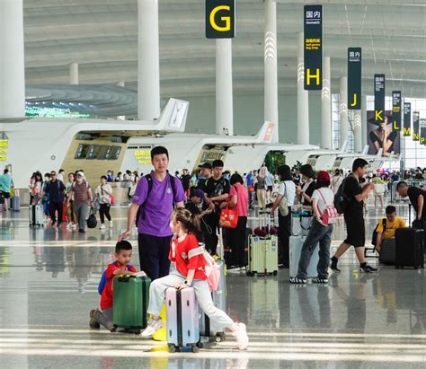 passengers boarding a domestic chinese flight at guangzhou baiyun airport with umbrellas during rain