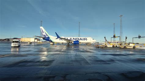 Passengers boarding PLAY aircraft during sunrise at Keflavík Airport