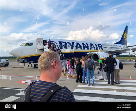 passengers boarding Ryanair aircraft at Paris-Beauvais Airport on a sunny afternoon