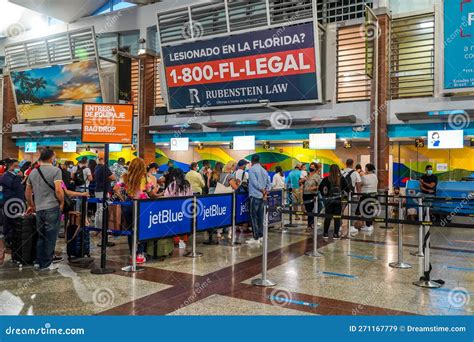 passengers queuing at JetBlue check-in counter amid news of service cuts and route eliminations
